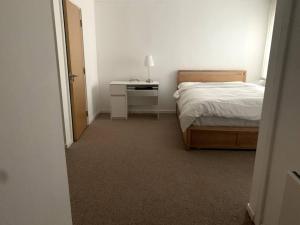 利兹Large Private Flat in City Centre Leeds的一间卧室配有一张床和一张带台灯的书桌