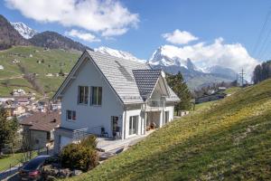 Alt Sankt JohannNew Chalet with breathtaking views!的山丘上的白色房子,背景是群山
