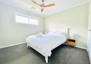 努尔卡巴Coolalta Cottage - Hunter Valley的卧室配有白色的床和吊扇