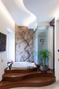 卡利亚里Palazzo Ferrucci Luxury Suites的带浴缸和盆栽的浴室