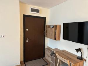 鲁塞Green Park Apartment - Brand New Studio!的一间设有门、一张桌子和一台电视的房间