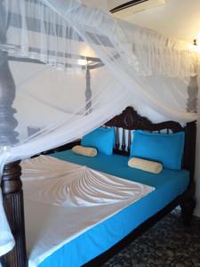 坦加拉Pearl Cave Cabanas & Resturant的天蓬客房的一张床位