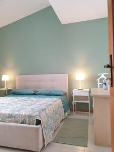 马里纳-迪-皮特拉桑塔Casetta Donatello的一间卧室配有一张大床和两盏灯。