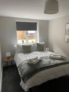 金斯林Cedar House - 2 bedroom house with free parking by ShortStays4U的一间卧室配有一张床,上面有两条毛巾