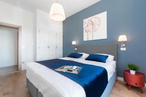 拉巴克Apartment Zulijani House Helis B7的一间卧室配有一张带蓝色墙壁的大床