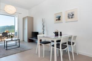 拉巴克Apartment Zulijani House Helis B7的白色的用餐室配有白色的桌椅