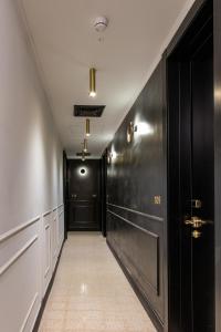 特拉维夫Theodor Brown Rothschild Tel-Aviv, a member of Brown Hotels的走廊设有黑色门,铺有瓷砖地板