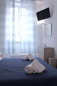 卢卡The Walls的卧室配有带2条毛巾的窗户,位于床上