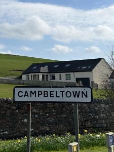 坎贝尔城Inveroran的石墙和房子前面的街道标志