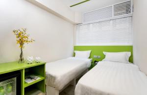 香港Pop E INN-B&B的绿白色客房内的两张床