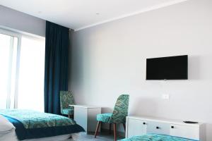 赫尔格达Shellghada Blue Beach的酒店客房设有两张床和一台墙上的电视。