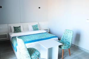赫尔格达Shellghada Blue Beach的小房间设有一张床、一张桌子和椅子