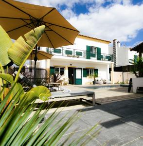 孔波尔塔Casa Idalia Boutique Hotel的房屋设有带长凳和遮阳伞的庭院