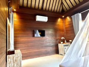 珀尼达岛Villa Vilah的客房设有木墙和电视。