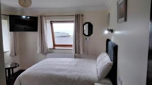 西班牙角Lahiff's Bay View Guest House的卧室配有白色的床和窗户。