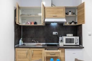 瓦尔纳E-home Apartments的厨房配有水槽和微波炉