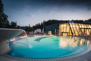 多布尔纳Hotel Švicarija - Terme Dobrna的一座大楼前带喷泉的大型游泳池