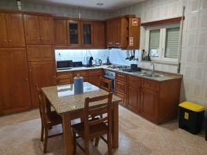 维拉·雷阿尔Cantinho dos Montes的厨房配有木制橱柜和桌椅