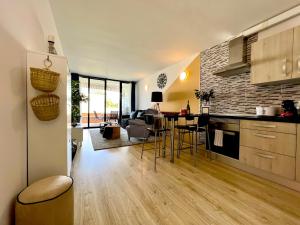 阿罗纳Stunning lovely flat with Pool and strong Wi-Fi的厨房以及带桌椅的起居室。