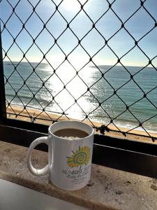 维拉维尔哈Praia da Costa, SUNRISE STAY的坐在靠近海洋的窗台上喝杯咖啡