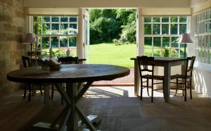 隆霍斯雷Thistleyhaugh farmhouse的一间带桌椅和窗户的用餐室