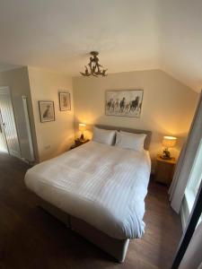 林德赫斯特The New Forest Inn的一间卧室配有一张带两盏灯的大型白色床。