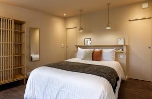 杜瓦讷内提伊马德酒店的卧室配有一张带白色床单和枕头的大床。