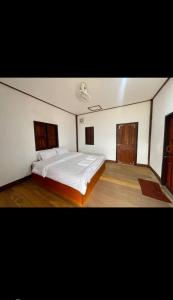 Ban OKonglor Khamchalern Guesthouse and Restaurant的卧室配有一张白色大床