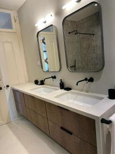 里斯本Eco Luxury apartment LISBOA-Campo de Ourique的一间带两个盥洗盆和大镜子的浴室