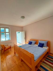GložanEthno&Coffee House Tulip的一间卧室配有一张带蓝色枕头的大型木制床。