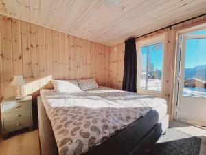 弗罗达尔Holiday cabin in beautiful surroundings的一间卧室设有一张床和一个大窗户