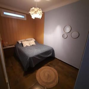 科莱拉Colera, Mar amunt的一间卧室配有一张床、地毯和吊灯
