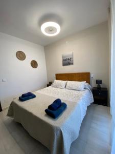 坎布里尔斯Versailles-mar的一间卧室配有一张大床和蓝色枕头