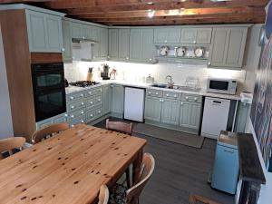 科文The Stables, Bron Y Graig, Corwen的厨房配有木桌、木桌和木桌。
