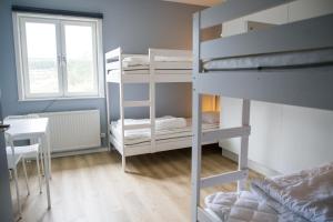 奥萨奥尔萨格隆利特旅舍的客房设有两张双层床、一张桌子和一扇窗户。
