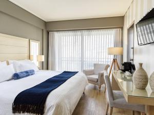 雅典海景酒店的一间卧室配有一张床、一张桌子和一把椅子