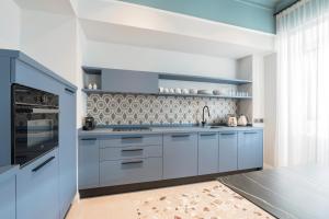罗马Be Mate Trastevere II的厨房配有蓝色橱柜和炉灶。