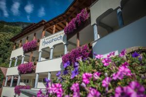 卡斯泰尔贝洛Panorama Hotel Himmelreich的一座在前面布满紫色花的建筑