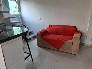 博西坎加Casa nova com 3 quartos, equipada com Ar Condicionado, TV, Internet e Área de Lazer Completa - Boiçucanga的客厅配有一张带红色毯子的沙发