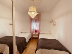 拉斯内格拉斯Apartamento Cerro del Aire的一间卧室配有两张床和吊灯。