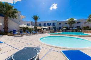 法维尼亚纳Resort Cala La Luna的度假村设有2个游泳池和椅子,并种植了棕榈树