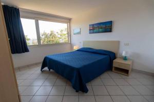 费拉约港Appartamenti Seccione的一间卧室设有蓝色的床和窗户。