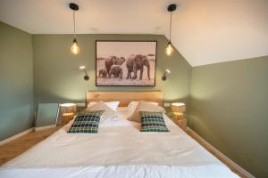 康村Hôtel Restaurant Le Fiacre à Quend plage的一间卧室配有一张大象照片的床