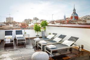 马德里埃里克佛克尔精品公寓酒店 - 马德里套房的阳台配有桌椅,享有城市美景。
