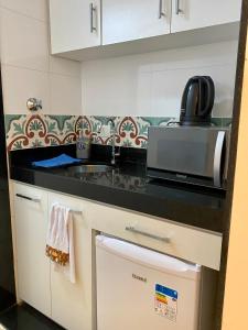 里约热内卢Apartamento Encantador Leme - Prédio na Orla的厨房配有水槽和微波炉