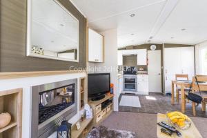 洛斯托夫特Brilliant Caravan With A Partial Sea View In Suffolk Ref 32026az的带电视的客厅和厨房