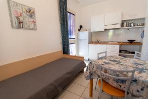 费拉约港Appartamenti Seccione的配有床和桌子的房间以及厨房
