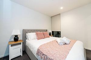 墨尔本Relaxing Urban Oasis的一间卧室配有一张床和一张带台灯的桌子