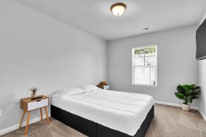 亚特兰大The GoodLiving Experience (Entire Town House)的白色的卧室设有一张大床和一个窗户