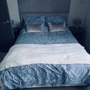 HordenCrimdon dean park的一张带蓝色和白色床单及枕头的床